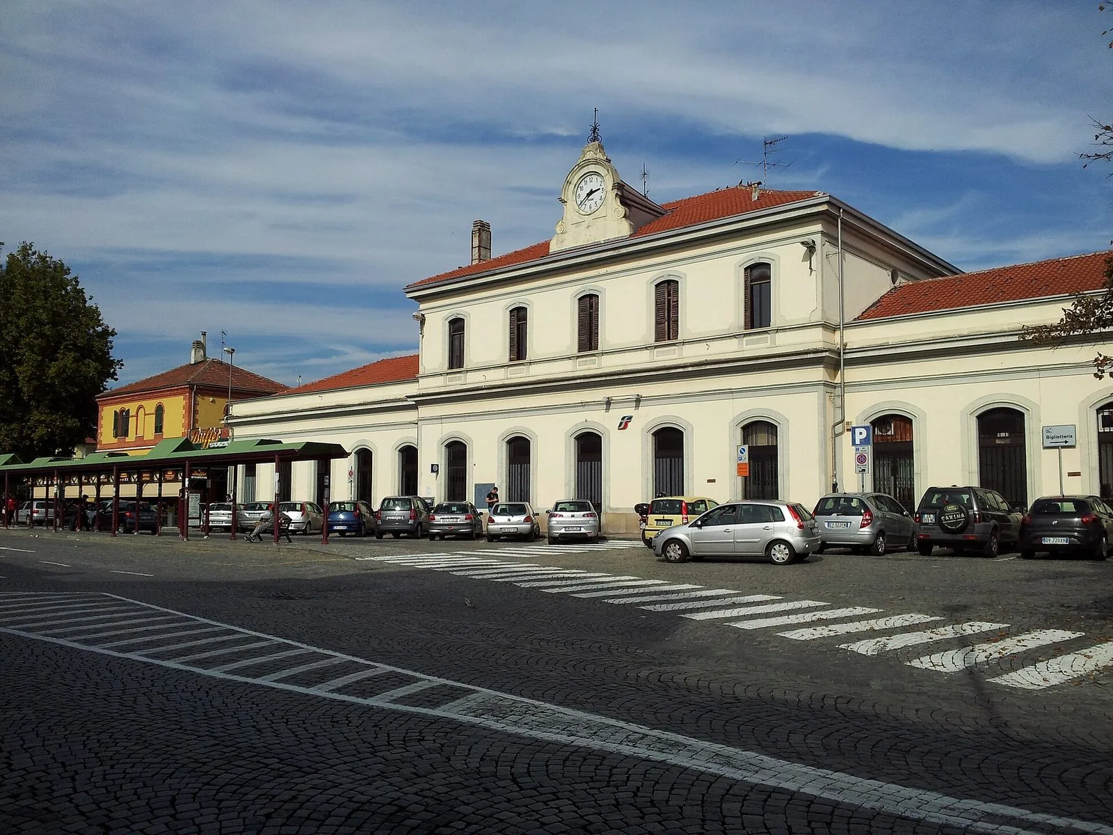 Facciata della stazione ferroviaria di Ivrea con l'orologio e il piazzale antistante
