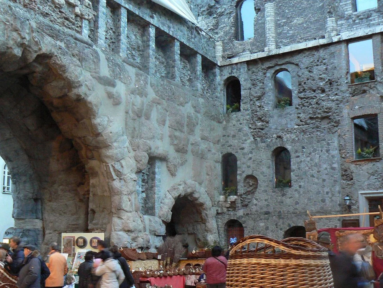 Cesti di vimini e bancarelle di artigiani ai piedi delle antiche mura romane di Aosta durante la Fiera di Sant'Orso